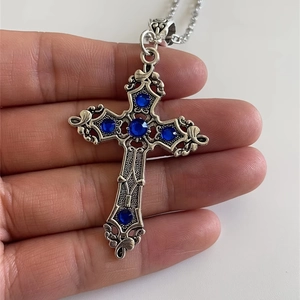 Detailed view of vintage silver cross necklace with five inlaid dark blue gemstones