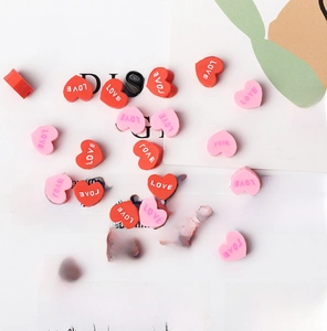 Macro detail of red and pink polymer clay heart beads with LOVE letters for DIY jewelry