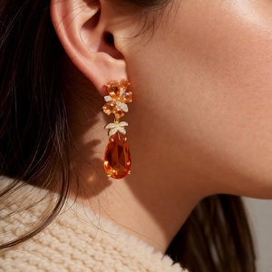 Vue rapprochée de boucles d'oreilles vintage avec zircon orange en poire et clou floral cristallin