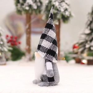 Christmas gnome doll with black and white plaid hat standing in a snowy forest scene
