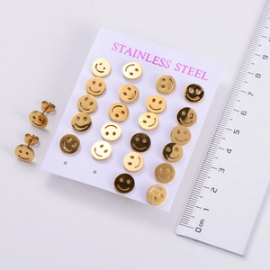 Detail view of gold smiley face stud earrings set with a ruler for size reference
