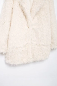 Detail shot of fluffy cream-white faux fur texture on a long-sleeved winter coat