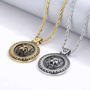 Détail de pendentifs tête de lion en or et argent avec chaînes torsadées en acier