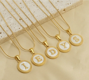 Detail of 18K gold plated snake chain necklaces with shell alphabet pendants I, E, D, Y, S