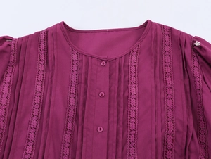Dettaglio del pizzo ricamato e delle pieghe verticali su un abito boho viola