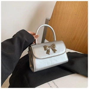 Dettaglio di una borsa a mano argento metallizzato con fibbia decorativa a forma di fiocco