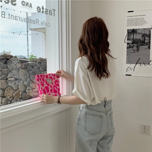 Detail view of pink leopard print tote bag with woven texture and premium brand label