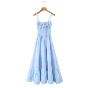 Détail de robe longue en coton bleu clair avec broderie anglaise et volants élégants