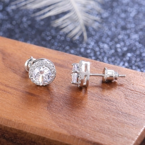 Classic round cubic zirconia stud earrings with halo design on a rustic wood background
