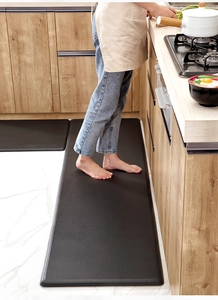 Kitchen scene with person standing on thick black anti-fatigue PU leather floor mats