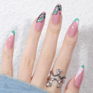 Almond press-on nails with butterfly pattern and pastel French tips on stone background
