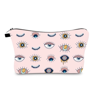 Detailed view of the water-resistant pink makeup bag with evil eye patterns and zipper