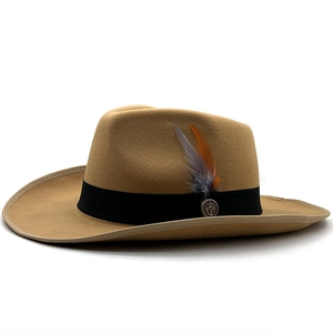 Detail of camel wool felt fedora featuring black grosgrain ribbon and feather ornament