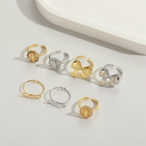 Detail of seven bow-knot and religious portrait rings in gold and silver adjustable design