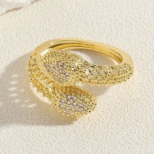 Close-up of golden hollow snake ring with sparkling zircon stones and textured finish