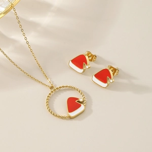 Macro shot of gold-plated Christmas hat necklace and stud earrings jewelry set