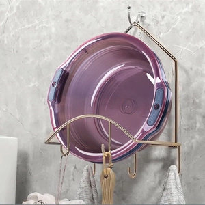 Purple transparent foldable washbasin with handles hanging on a bathroom wall rack