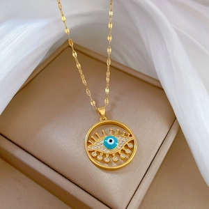 Detailed close-up of golden evil eye pendant with blue crystals on silk background