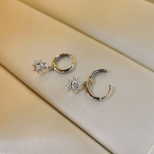 Macro detail of silver S925 sunburst hoop earrings with sparkling zircon stones