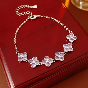 Detailed macro of silver flower bracelet with purple zircons on a luxury wood box
