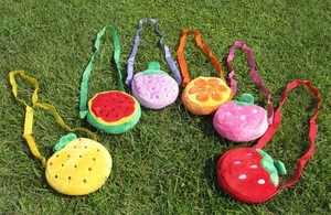 Collection of plush fruit crossbody bags for kids including strawberry and pineapple