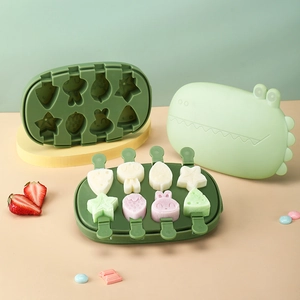 Green silicone dinosaur ice mold set with 8 cartoon shapes and lid on yellow base