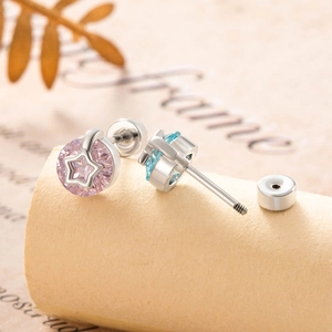 Star-shaped cartilage piercings with pink and blue zircons and screw-back closure