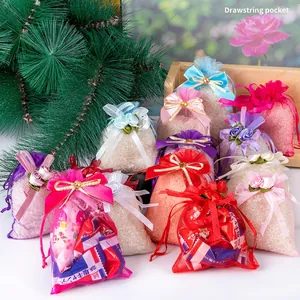 Colorful organza drawstring gift bags with ribbon bows and floral accents for candy packing