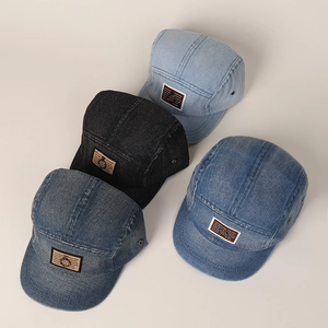 Detailopname van vier gewassen denim vijf-panel baseballcaps met vintage leren patches erop