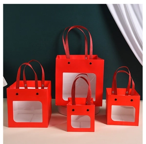 Red gift bags with windows in four sizes displayed against a green background