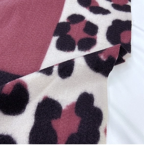 Detail of soft leopard print scarf with pink color blocking and fringed textures