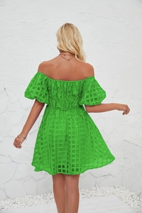 Détail de robe verte à épaules dénudées avec taille smockée et tissu jacquard à carreaux