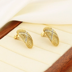 Macro shot of gold-plated oval earrings with beaded texture and micro-pave zircons