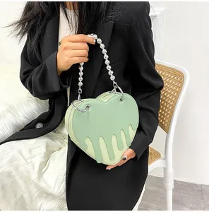 Detail of light green heart bag with liquid drip 3D relief and pearl chain handle