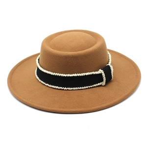 Close-up of camel wool felt boater hat with black ribbon and delicate bead chain detail