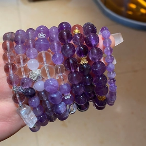 Detailed macro of multi-layered amethyst bead bracelet with silver crown and metal accents