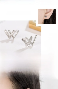Macro detail of silver W-letter earrings with shimmering cubic zirconia and mirror finish