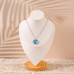 Elegante espositore per collane in legno massiccio con ciondolo a cuore blu e ombre di palme