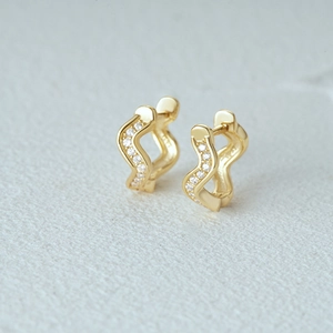Macro shot of S925 sterling silver gold wavy hoop earrings with clear cubic zirconia