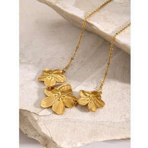 Elegant 18k gold stainless steel necklace with three flower pendants on natural stone