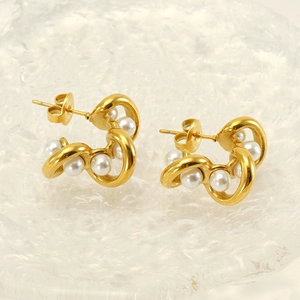 Macro view of 18K gold-plated C-shaped wave earrings featuring elegant white pearls