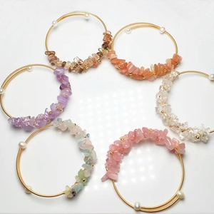 Detail of six handmade wire-wrapped crystal bracelets with diverse gemstones and pearls