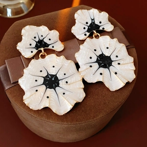 Détail de boucles d'oreilles vintage en émail de ginkgo sur une boîte en velours