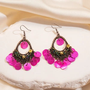Detail of vintage Bohemian drop earrings with magenta shell sequins and bronze filigree