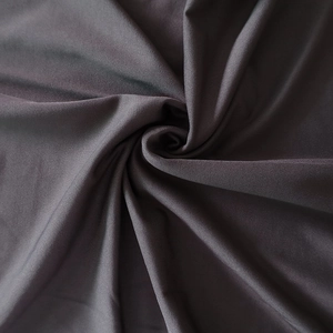 Détail du tissu extensible gris foncé avec une texture lisse et un drapé élégant