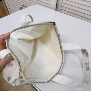 Close-up of the spacious interior with beige lining and gray zipper of the floral tote