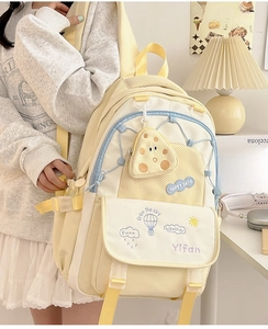 Detail of yellow and blue backpack featuring multi-compartments and a cheese coin purse
