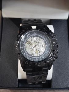 Macro detail of men's black automatic skeleton watch with visible gears and alloy dial