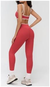 Dettaglio dei pantaloni da yoga rossi a vita alta con bordo bianco e vestibilità slim