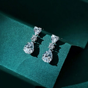 Detailed shot of 925 silver drop earrings with heart and pear-cut clear stones
